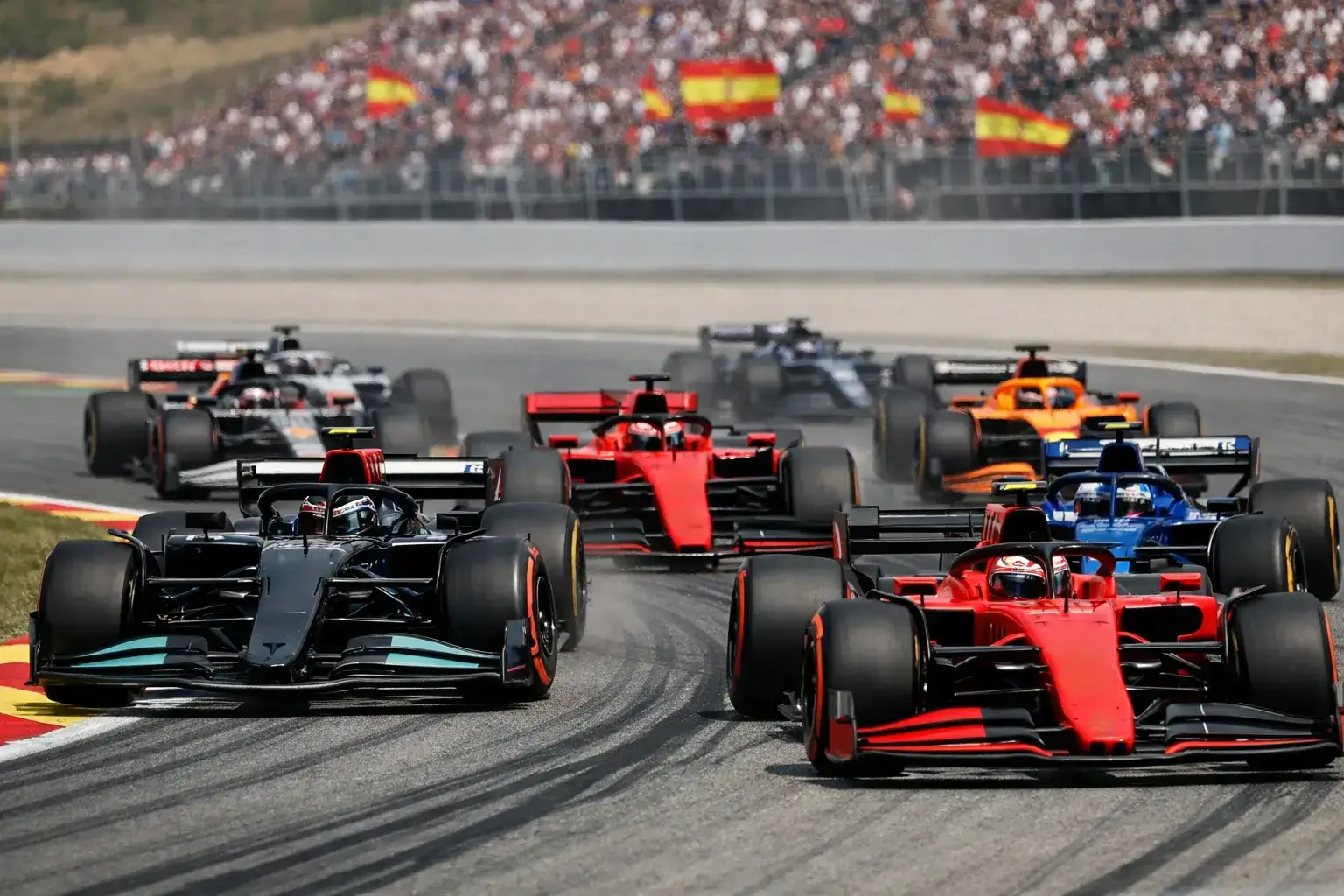 Monoplazas de F1 luchando por posición en la primera curva
